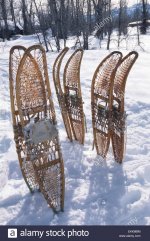 three-pairs-of-traditional-wood-frame-snowshoes-stand-on-end-in-the-EKKMBM.jpg